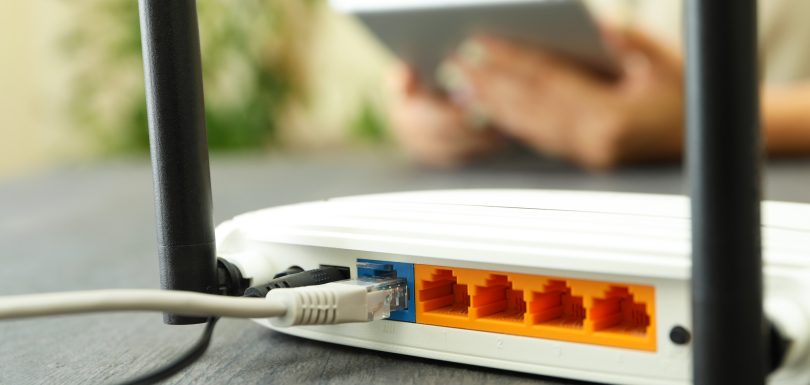 Wi - fi router on gray wooden table, close up