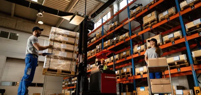 High-bay warehouse aisle with tall racking and forklifts