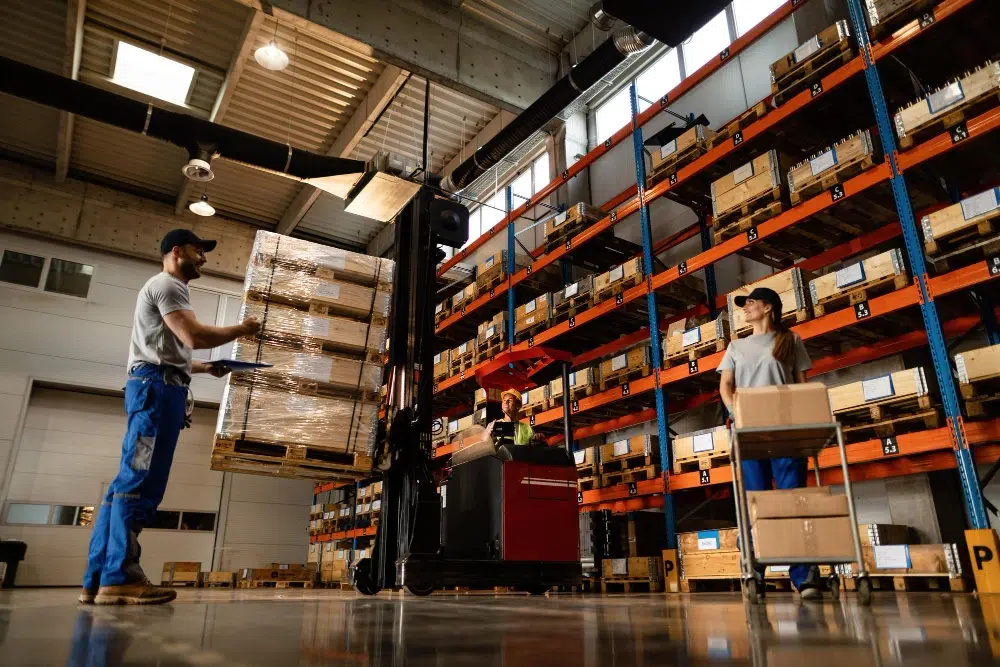 High-bay warehouse aisle with tall racking and forklifts